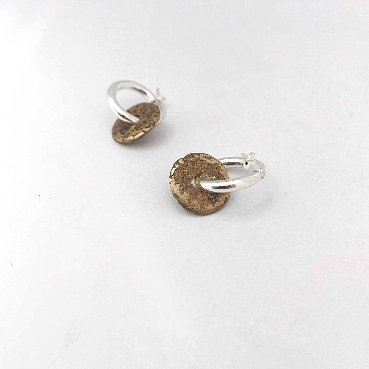 Medium sized sandcast bronze donut on silver hoop by contemporary jeweller Savage Jewellery