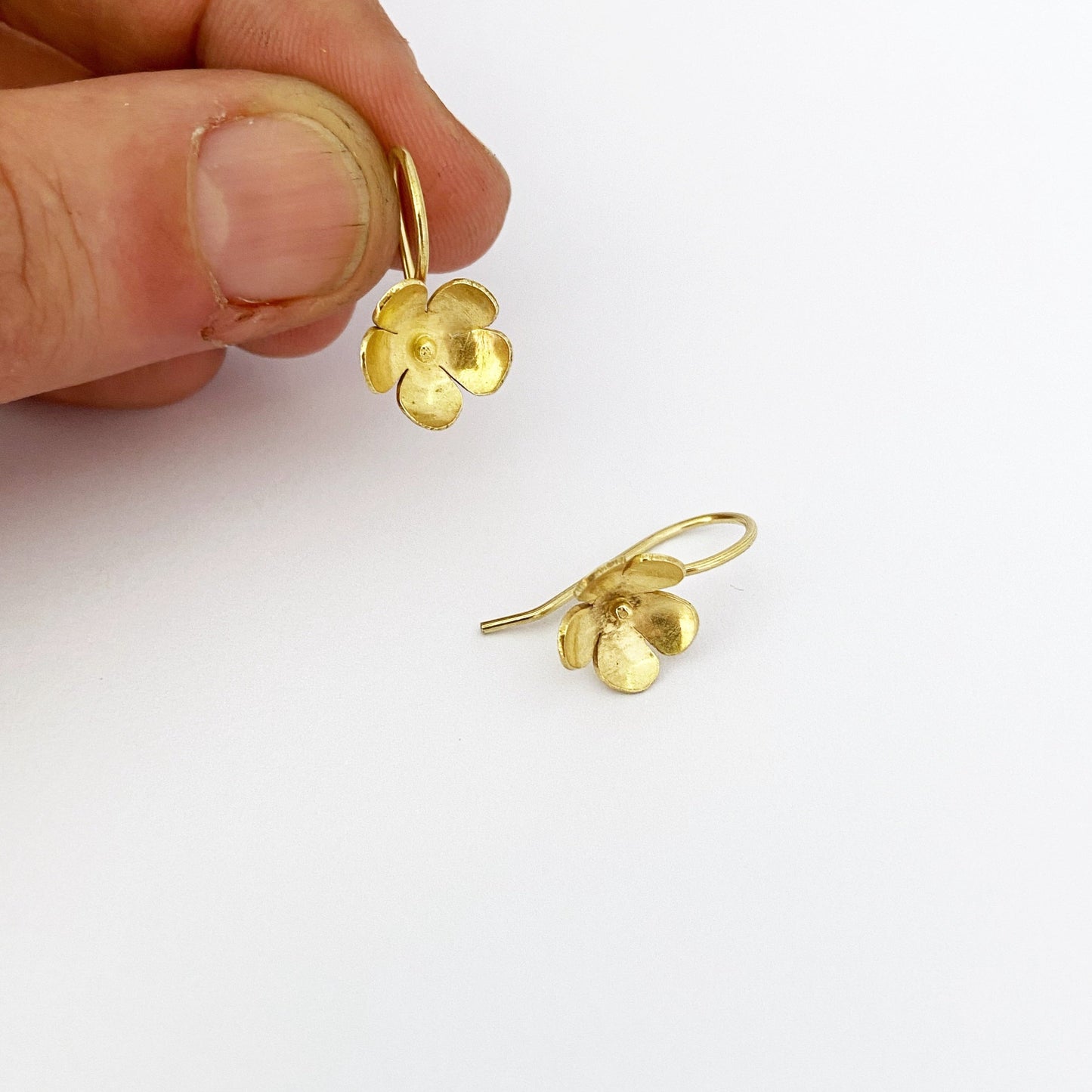 Jewellers hand shows flower drop earring