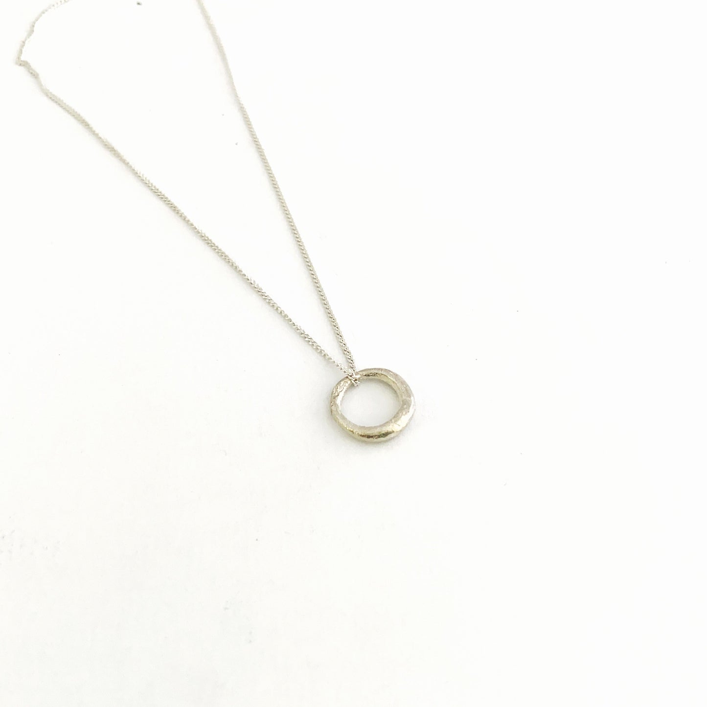 Small organic silver circle pendant on chain