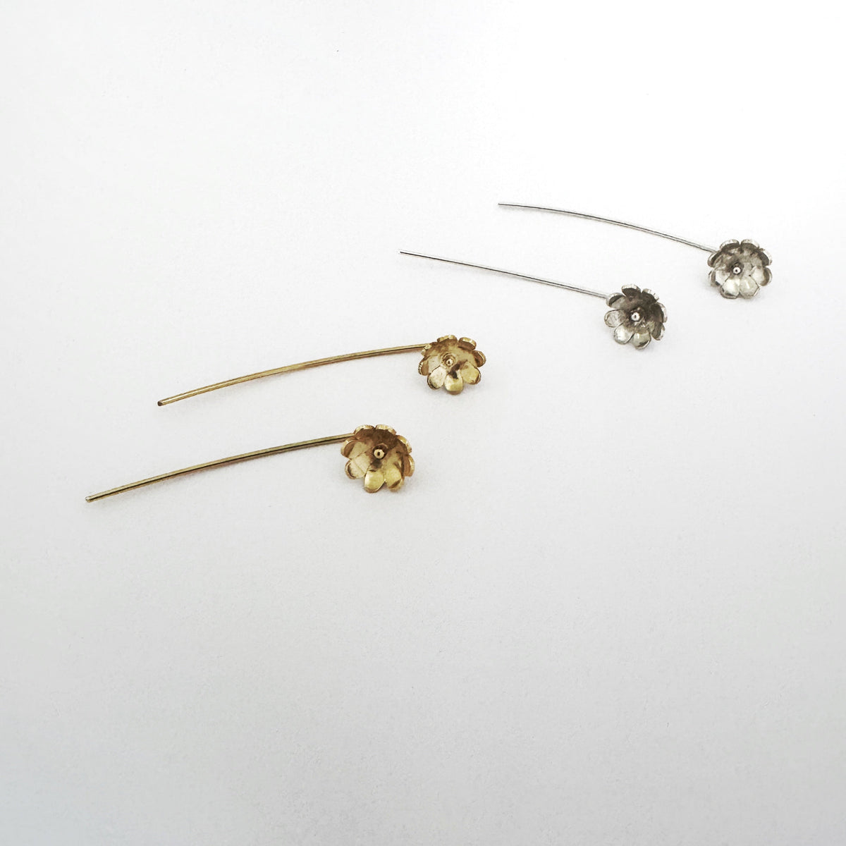 Sterling silver and gold daisy stick earrings, flower on earlobe with stick behind